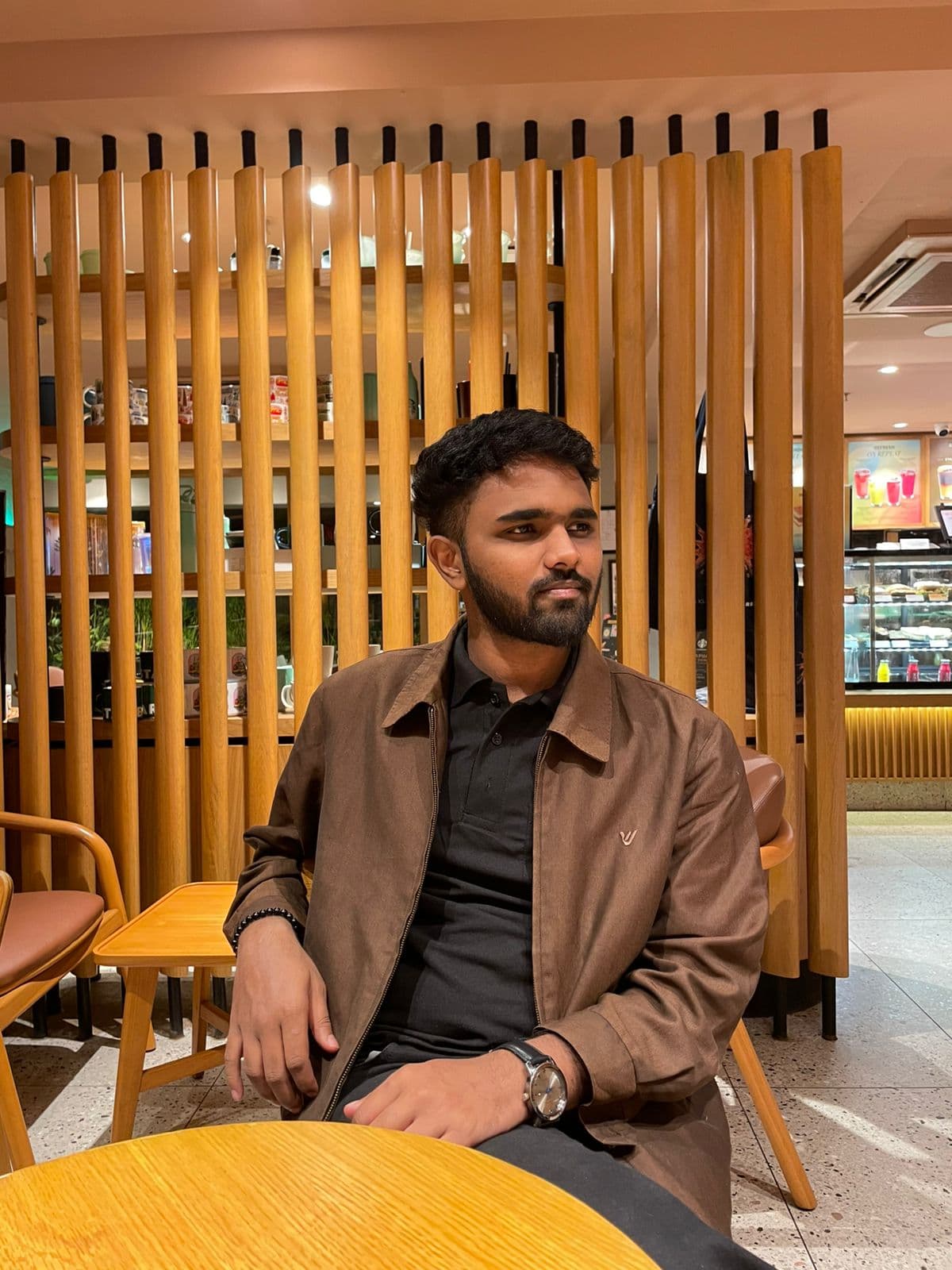 Affan Shaikhsurab coding at a cafe workspace